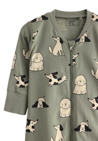 Grön zip-up overall med ett lekfullt hundtryck i kräm och svart. Mjukt material med korta ärmar och rundad halsringning.