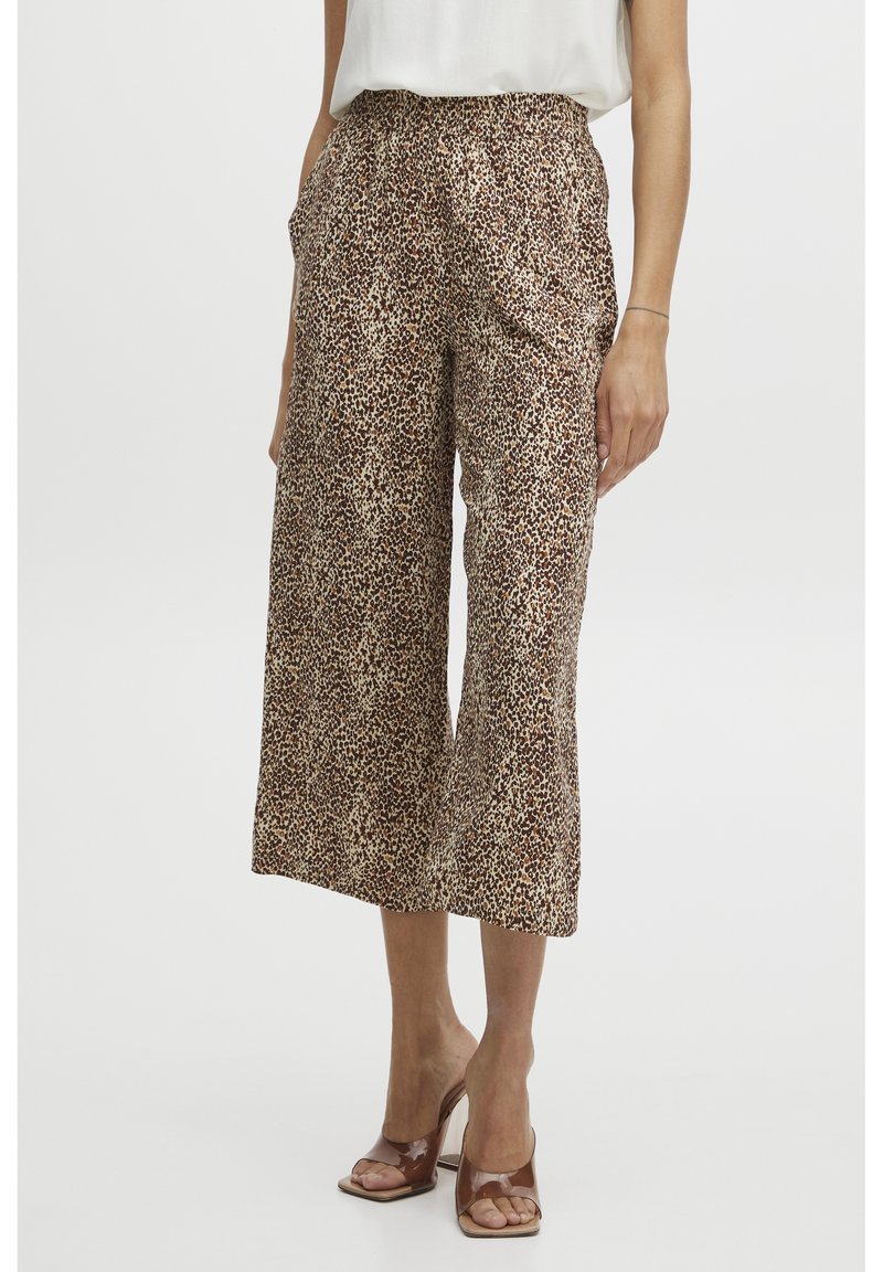 Skrojone, szerokie spodnie w kolorze brązowym w wzór lamparta. Wykonane z lekkiego materiału, z elastycznym paskiem w talii i bocznymi kieszeniami.
