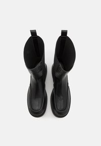 Mustad mustad nahast pahkluu saapad, millel on sile pind, elastsed külgpaneelid, tugevdavad varbakaandid ja kummist tallad, pakkudes kaasaegset siluetti.