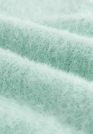 Lys mintgrøn tekstureret stof med et blødt, fuzzy udseende, der har fine fibre og en subtil glans, foldet i bløde bølger.