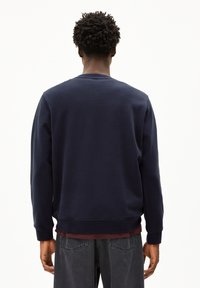 Marineblauwe sweatshirt met een ronde hals, ribgebreide manchetten en zoom. Gemaakt van zachte stof, heeft het een minimalistisch ontwerp zonder zichtbare logo's.