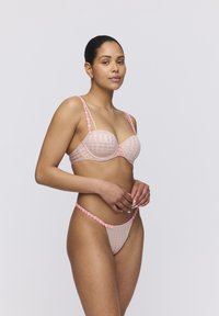 Lichtroze doorschijnend lingeriesetje met kantafwerking, voorzien van een geruit patroon, een beugelbh en dunne bandjes met bloemenaccenten op de string.