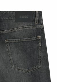 Jeans in denim grigio con una tasca posteriore caratterizzata da un distintivo accento "B", una patch in pelle nera e dettagli di cucitura a contrasto.