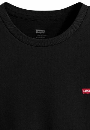 Schwarzes Levi's T-Shirt mit Rundhalsausschnitt, kleinem rotem Levi's-Logo auf der linken Brust und bedrucktem Etikett im Kragen.