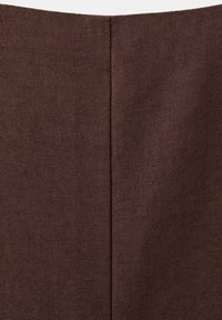 Gros plan sur un tissu marron avec une couture verticale au centre, montrant la texture et les détails de la couture.