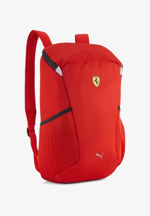 Jaskrawoczerwony plecak z logo Ferrari i Puma, dwiema paskami na ramiona i czarnymi akcentami po bokach, pokazany na białym tle.