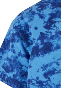 Kortermet skjorte i et blått tie-dye mønster med varierende nyanser av blått, glatt bomullstoff og rund halsdesign.