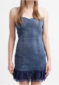 Sukienka dżinsowa z dopasowanym gorsetem, dekoltem w kształcie serca i rozszerzaną granatową koronką u dołu. Posiada pionowe detale szycia.