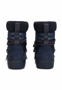 Stivali blu navy con finitura in suede, colletto lavorato a maglia e lacci a fantasia. Presentano dettagli con logo e un tacco testurizzato.
