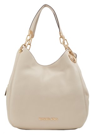 Beige leren Michael Kors handtas met gouden kettingschakels aan de band en een rond merklogo bedeltje dat aan het handvat hangt.