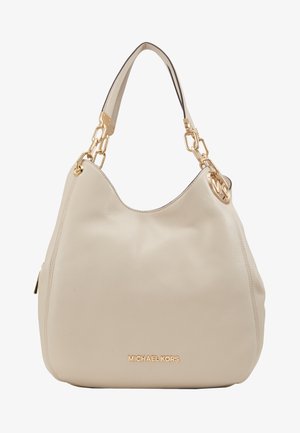 Beige leren Michael Kors handtas met gouden kettingschakels aan de band en een rond merklogo bedeltje dat aan het handvat hangt.
