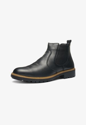 Schwarzer Chelsea-Stiefel aus Leder mit elastischem Seitenteil, beige Naht entlang der Sohle und profilierter Gummisohle, schräg nach links auf weißem Hintergrund.
