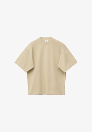 Beige oversized short-sleeve crew neck T-shirt laid flat with visible stitching on sleeves and hem against white background.