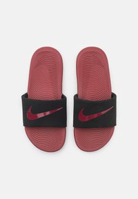 Chanclas negras con una correa ancha, con un logo de Nike rojo brillante. Plantilla texturizada roja con surcos para mayor agarre y comodidad.