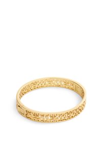Pulsera de brazalete en tono dorado que presenta un intrincado patrón de calado, bordes suaves y un cierre seguro. Ligera, con un acabado pulido.