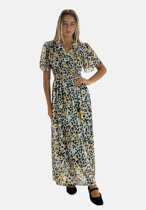 Abito lungo in tessuto leggero con stampa leopardata in beige e nero, caratterizzato da maniche a sbuffo e vita elastica. Scarpe nere completano il look.