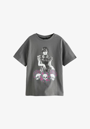 Szara bawełniana koszulka z grafiką dziewczyny w sukience z falbanami, ozdobionej czaszkami i różowymi kwiatami. Krótkie rękawy i okrągły dekolt.