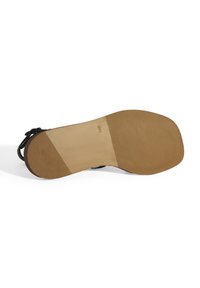 Schwarze Schuhsohle mit einem glatten braunen Bereich, der eine strukturierte Oberfläche für besseren Halt aufweist. Riemen sind an der Ferse sichtbar. Abgerundete Form.
