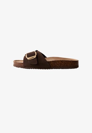 Sandalia tipo diapositiva marrón con una correa ancha y un acento de hebilla dorada. Plantilla de corcho texturizada y una suela plataforma resistente.