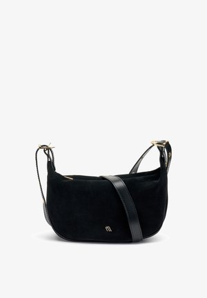 Zwarte suède crossbody tas met een leren schouderband, gouden hardware accenten, een zachte textuur en een ronde vorm. Bevat een klein logo detail.