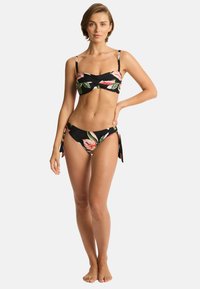 Twee-delige bikinitopset met een zwarte achtergrond en bloemenpatronen in roze en groen. Verstelbare schouderbanden en een bikini broekje met striksluiting aan de zijkanten.