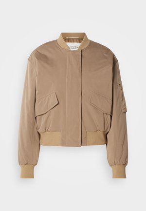 Casaco bombardier bege com punhos e bainha canelados, apresentando dois bolsos frontais com aba e um bolso lateral com fecho de correr. Tecido liso, ligeiramente brilhante.