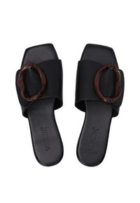 Zwarte slidesandalen met een brede band en een grote bruine ronde accent. Gladde lederen textuur en vierkante tenen. Minimalistisch design.