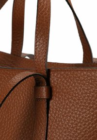 Borsa tote in pelle marrone con superficie testurizzata e bordi neri a contrasto; presenta doppi manici e un design strutturato.