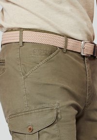 Olivgrüne Cargo-Hose aus strukturiertem Stoff mit seitlicher Tasche; ausgestattet mit einem gewebten rosa Gürtel mit silberner Schnalle.