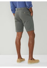 Grå bomulds shorts med lige pasform, baglommer med knaplukning, parret med beige ruskinds slip-on sko.