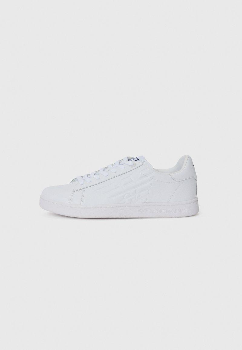 Adidași albi cu un superior din piele netedă, talpă din cauciuc plat, detaliu cu logo embosat pe lateral și șireturi plate. Designul este minimalist și curat.