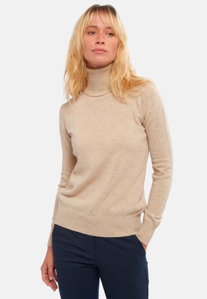 Pull à col roulé beige fait d'un tissu doux, avec une coupe ajustée, des poignets et un ourlet côtelés, une texture lisse et peu d'ornementations.