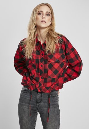 Red and black checkered shirt with a button-up front, chest pockets, adjustable drawstring hem, and long sleeves.