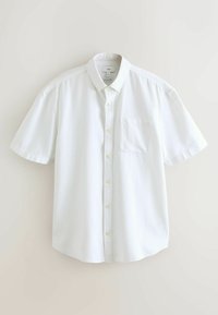 Chemise blanche à manches courtes avec boutons, col et poche poitrine, en tissu en lin, présentée sur un fond uni.