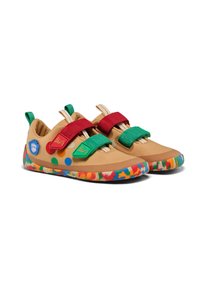 Scarpe in tessuto beige con strappi in velcro rossi e verdi, accenti a pois colorati e una suola a motivo multicolore, progettate per l'abbigliamento attivo.