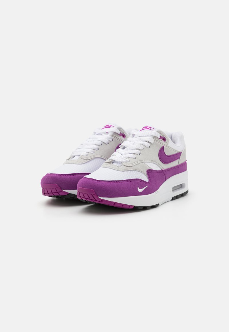 Witte en paarse Nike Air Max sneakers met een bovenwerk van suede en mesh, ronde neus, vetersluiting en luchtkussens in de zool.