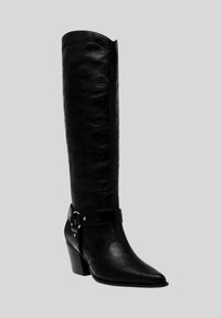 Stivale in pelle nera al ginocchio con punta affilata, finitura testurizzata e una cinghia decorativa con accessori in argento attorno alla caviglia.