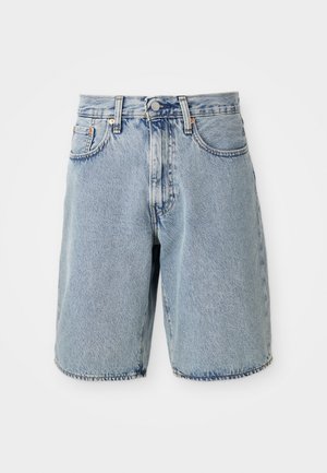 Svetlomodré riflové šortky s vysokým pásom, rovného strihu, s rozstrapkaným lemom, piatimi vreckami a zapínaním na gombík. Viditeľná distressed textúra.