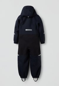 Marineblå vandtæt overalls med hætte, der har grå detaljer, elastiske manchetter og reflekterende striber på skuldrene og benene.