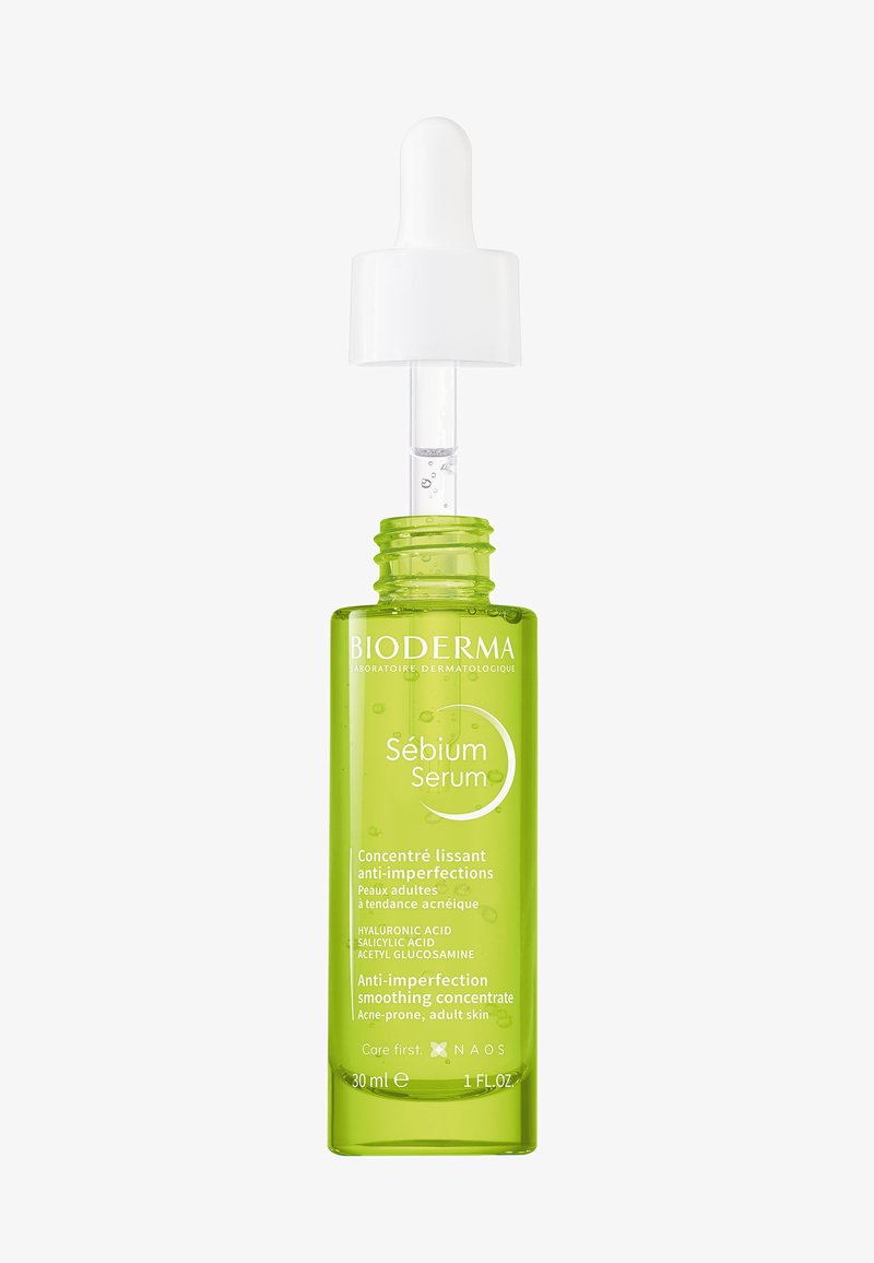 Grüne Bioderma Sébium Serumflasche mit Tropfer, beschriftet als Anti-Unreinheiten-Glättungskonzentrat für zu Akne neigende erwachsene Haut, 30 ml.