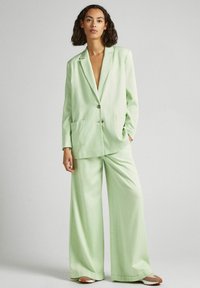 Light green wide-leg suit featuring a tailored blazer with two front pockets, single button closure, and matching loose-fit pants.