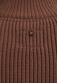 Bruine geribde gebreide trui met een textuur en een klein zwart en gouden "PME Legend" logo label op de voorkant.