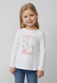 Witte lange mouwen shirt met een kleurrijke eenhoornafbeelding en de tekst "DROMEN KOMEN UIT" en de zin "WAAR MAGIE DE NACHT VULLET."