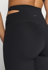 Μαύρες κολάν από ελαστικό ύφασμα με ψηλή μέση. Διαθέτουν μια μικρή σχισμή στο πλάι και ραφές flatlock.