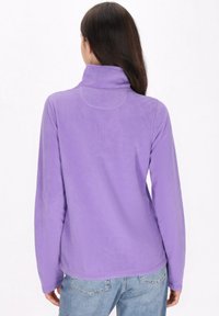 Pullover in pile di colore lilla chiaro con colletto alto, maniche lunghe e texture morbida, caratterizzato da un orlo arrotondato. Adatto per un abbigliamento casual.