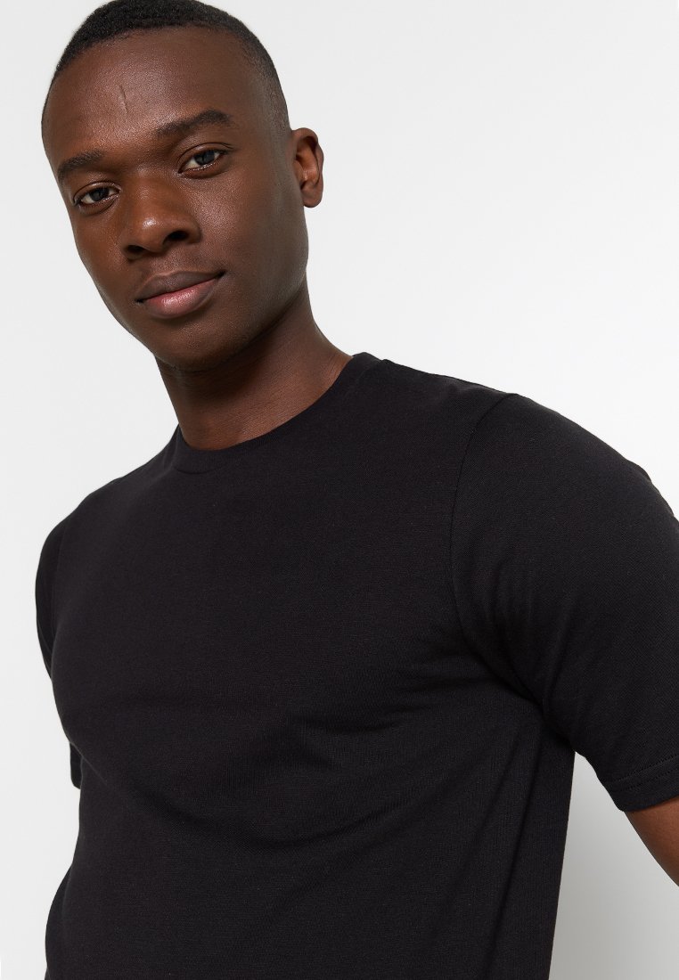 Schwarzes Kurzarm-T-Shirt aus Baumwolle mit klassischem Rundhalsausschnitt und glatter Textur, enganliegender Silhouette.