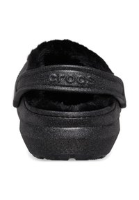 Zwarte glinsterende instapschoen met een fluffy zwarte voering en een brede band. Gstructeerde zool voor grip. Zacht materiaal en ronde vorm.