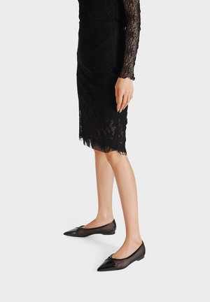 Ballerine in mesh nero con punta affusolata e dettagli in vernice nera. Progettate con una suola flessibile per comfort e facilità d'uso.