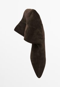 Stivali alti con tacco a punta slouchy in suede marrone scuro, con ampi risvolti sopra la caviglia.