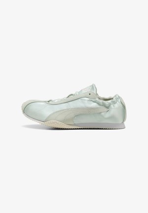 Baskets Puma vert clair avec bande logo en daim, arrière élastique et semelle texturée, vues de côté sur fond blanc.